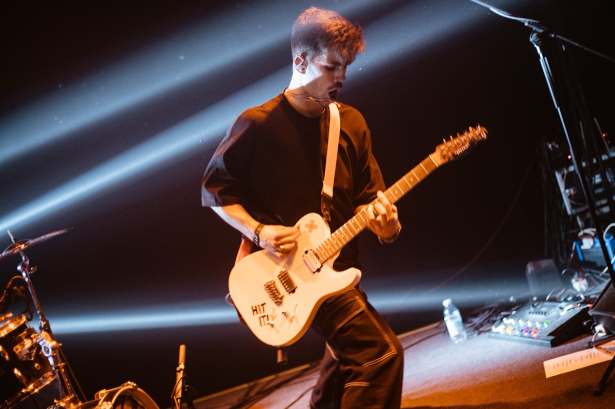 Alex Vale tocando guitarra ao vivo com a banda Zebra Libra