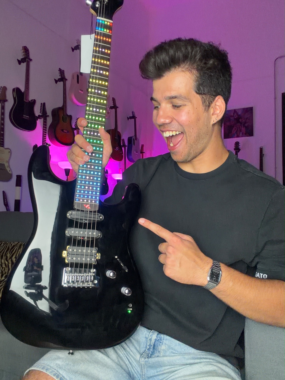 Alex Vale apontando para o braço de LED da guitarra